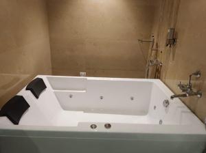 W łazience znajduje się biała wanna i umywalka. w obiekcie The Grand Legacy Resort & Spa - TGL - Pure Vegetarian Mahabaleshwar w mieście Mahabaleshwar