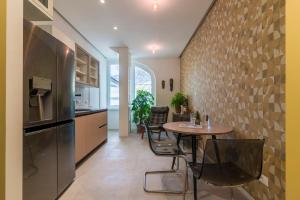 a kitchen with a table and a refrigerator at Electric Rooms & Suites in Trento