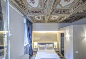 una camera con letto e soffitto a cassettoni di Little Queen Suite a Roma