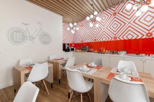 a dining room with a table and white chairs at Porta da Arrábida Suites in Palmela