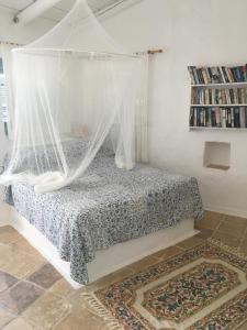 ein Schlafzimmer mit einem Himmelbett und einem Teppich in der Unterkunft Villa Xyloporta in Skinária
