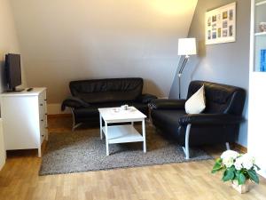 a living room with two leather chairs and a table at Seestern in Grömitz +15 photos