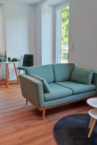 a living room with a blue couch and a table at Mosel-Blick: Charme & Komfort in Bremm
