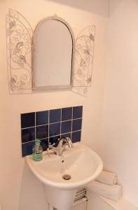 La salle de bains est pourvue d'un lavabo et d'un miroir. dans l'établissement Maison Pelissier - Chambres d’hôtes avec piscine, à Cuxac-dʼAude