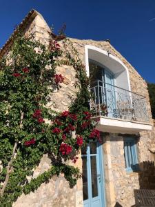 ein Gebäude mit einem Balkon mit roten Blumen darauf in der Unterkunft Villa Xyloporta in Skinária + 9 Fotos