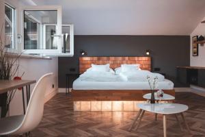 a bedroom with a large bed and a table at Villa Sonnenhof Boutique-Hotel in Bad Reichenhall