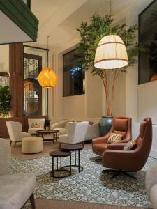 a lobby with couches and chairs and tables at H10 Casanova in Barcelona