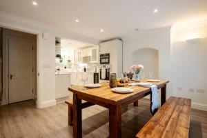 a kitchen with a wooden table and a dining room at Luxury 3BRs house in the heart of Victoria in London