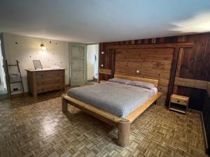 a bedroom with a bed and a wooden headboard at Profumo Di Legno, PaLù vacanze in Aosta +42 photos