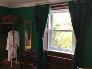 Mansefield Rooms في لوكربي: غرفة خضراء مع نافذة ومرآة