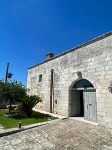 un gran edificio de ladrillo con una puerta grande en Masseria Giovanni, en Martano