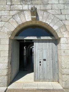 an archway with a wooden door in a stone building at Masseria Giovanni in Martano
