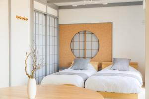 a bedroom with two beds and a mirror at Paysage 伊豆高原 in Ito