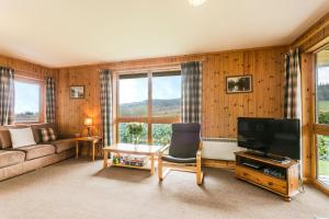 a living room with a couch and a television at Holly Lodge 4 Bedrooms Minehead in Minehead