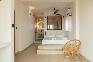 a bedroom with a white bed and a chair at Loft Ahangama in Ahangama