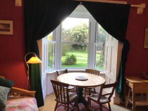Mansefield Rooms في لوكربي: طاولة وكراسي في غرفة مع نافذة