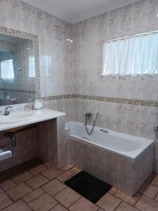 a bathroom with a tub and a sink at Pecan Farm Guesthouse in Louis Trichardt