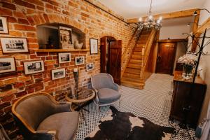 a living room with a brick wall and two chairs at Dom dla dwojga w Starym Młynie w Brzeźnicy in Brzeźnica