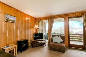 a living room with a couch and a tv and a fireplace at Yew Tree Lodge in Minehead