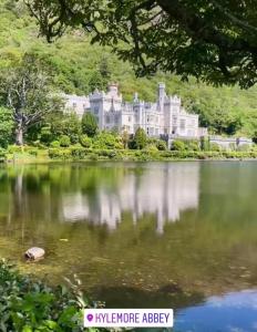 a large house on the edge of a lake at Boutique Townhouses Letterfrack Village - Entrance to Connemara National Park in Galway