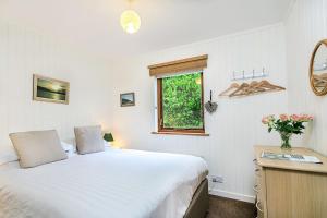 1 dormitorio con cama y ventana en Cedar Lodge Minehead en Minehead