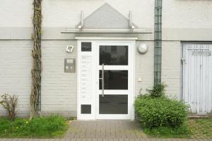 Una puerta blanca de una casa con en Möblierte 3-Zimmer-Wohnung nahe Düsseldorf in Duisburg-Süd, en Duisburg