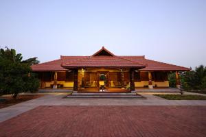 a house with a brick driveway in front of it at Panchavati Villa in Manipala