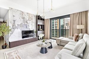 Luxury 2 Bedroom Apartment - Next to Dubai Opera في دبي: غرفة معيشة مع أريكة وتلفزيون