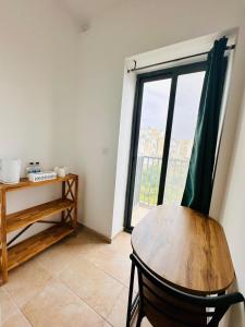 um quarto com uma mesa e uma grande janela em Dome Luju em Mosta