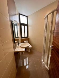 baño con aseo y lavabo y ventana en Dome Luju, en Mosta
