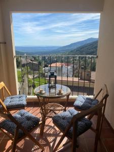 a balcony with a glass table and two chairs at Mirador del Tiétar in Mijares