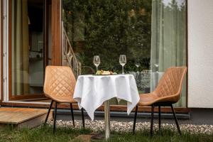 a table with two chairs and two glasses of wine at Hotel Ostseeland in Warnemünde