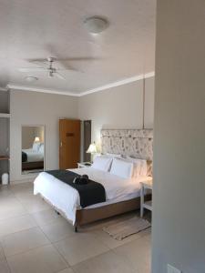 a large bedroom with a large bed and a mirror at Pecan Farm Guesthouse in Louis Trichardt