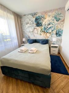 1 dormitorio con 1 cama grande y pared de flores en Apartament nad Zalewem, en Serock