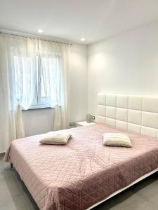 a bedroom with a large bed with two pillows on it at Apartment Diva in Zambratija