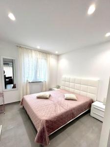 a bedroom with a large bed with a pink bedspread at Apartment Diva in Zambratija