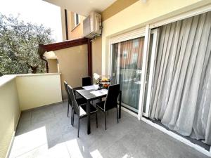 a balcony with a table and chairs on a balcony at Apartment Diva in Zambratija