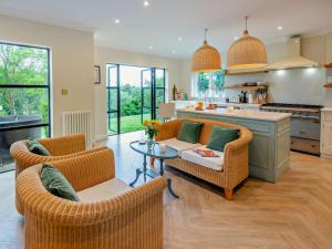a living room with two chairs and a table and a kitchen at Riverside House in Cookham