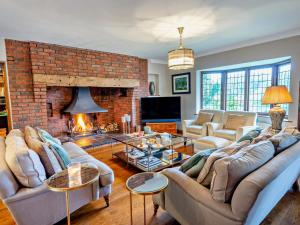 a living room with couches and a brick fireplace at Riverside House in Cookham