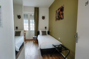 ベルドルフにあるTrail-Inn Natur & Sporthotelの小さな部屋で、ベッド2台、鏡が備わります。