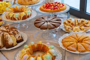 a table full of cakes and pastries on plates at Hotel Atlas in Cesenatico