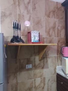 a shelf in a kitchen with utensils on it at بلو باي اسيا للعائلات فقط in Ain Sokhna