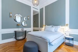 a bedroom with a bed and a chair and a mirror at Appartement de luxe in Paris