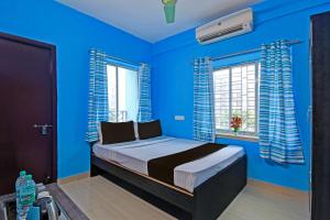 una camera blu con un letto con pareti e finestre blu di OYO ANA GUEST HOUSE a kolkata