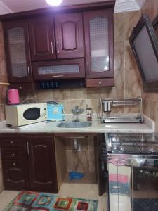 a kitchen with a sink and a microwave at بلو باي اسيا للعائلات فقط in Ain Sokhna +45 photos