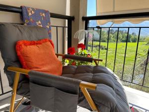 una sedia con cuscino arancione seduta accanto a una finestra di Sarf Farm Libohove a Libohovë