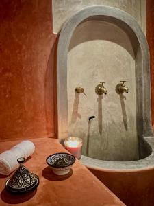 Riad Hotel Sherazade في مراكش: حمام مع مرآة ومغسلة
