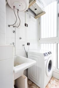 Un baño con lavadora y lavabo. en Vivienda vacacional El Pijaral, en El Roque