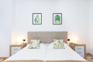 Un dormitorio con dos camas y dos mesitas de noche. en Vivienda vacacional El Pijaral, en El Roque