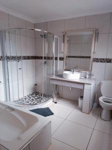 a bathroom with a tub and a sink and a toilet at Pecan Farm Guesthouse in Louis Trichardt